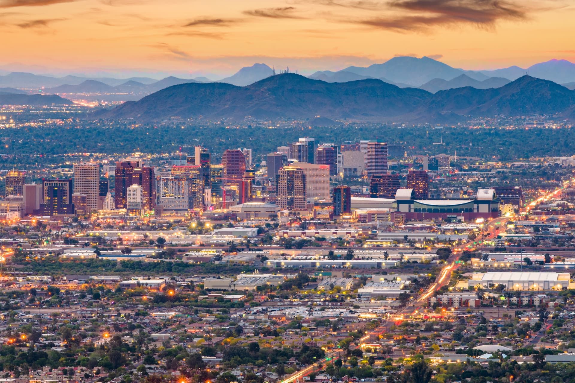 Downtown Phoenix skyline at dusk with mountains behind