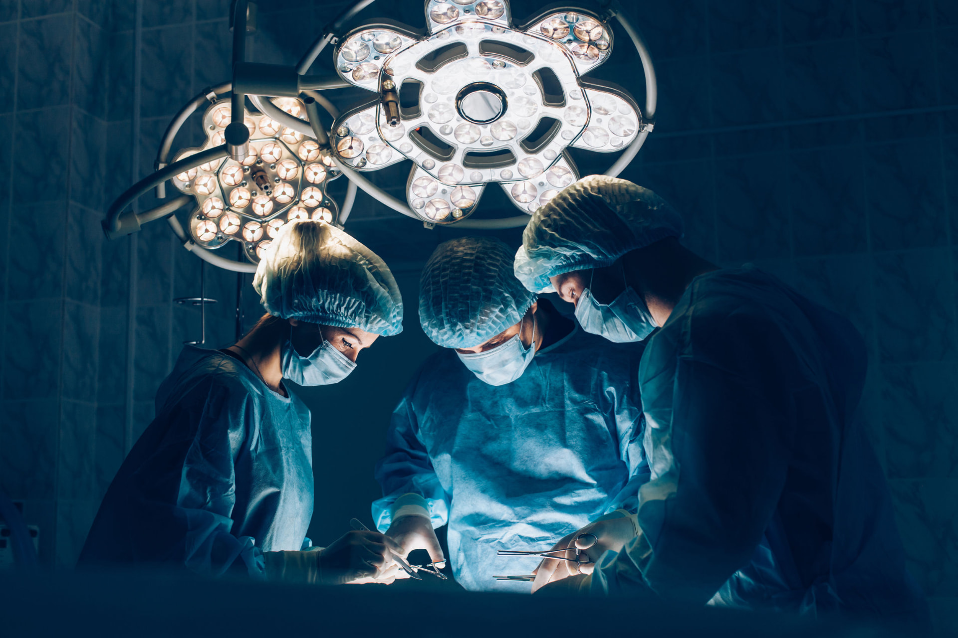 Surgical team working together under operating room lights
